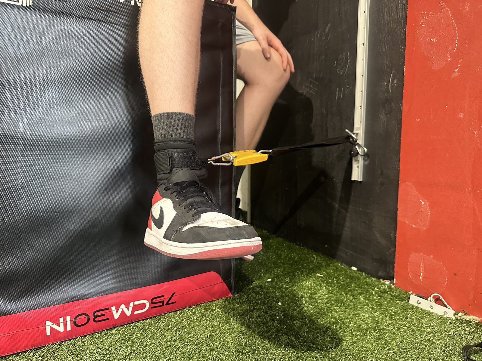 Athlete testing hip strength with the ForceIQ ankle connector