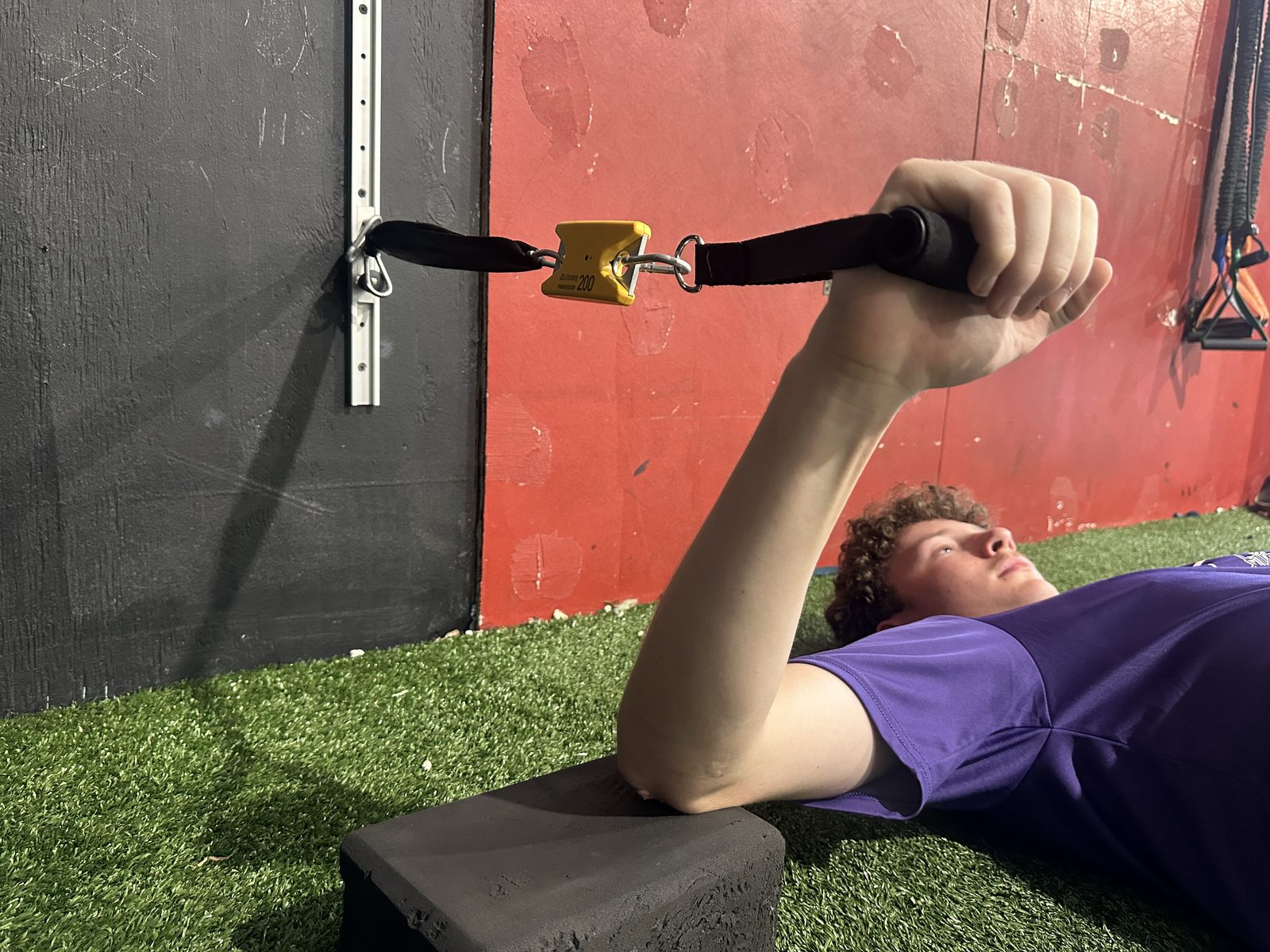 Athlete testing arm strength lying down with the ForceIQ grip connector