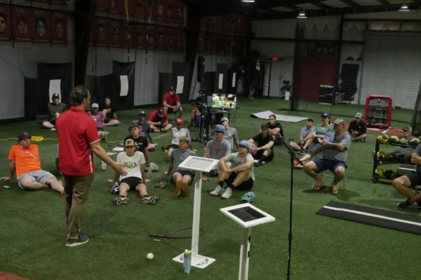 Coach leading group instruction on the turf inside the TopVelocity baseball training facility.