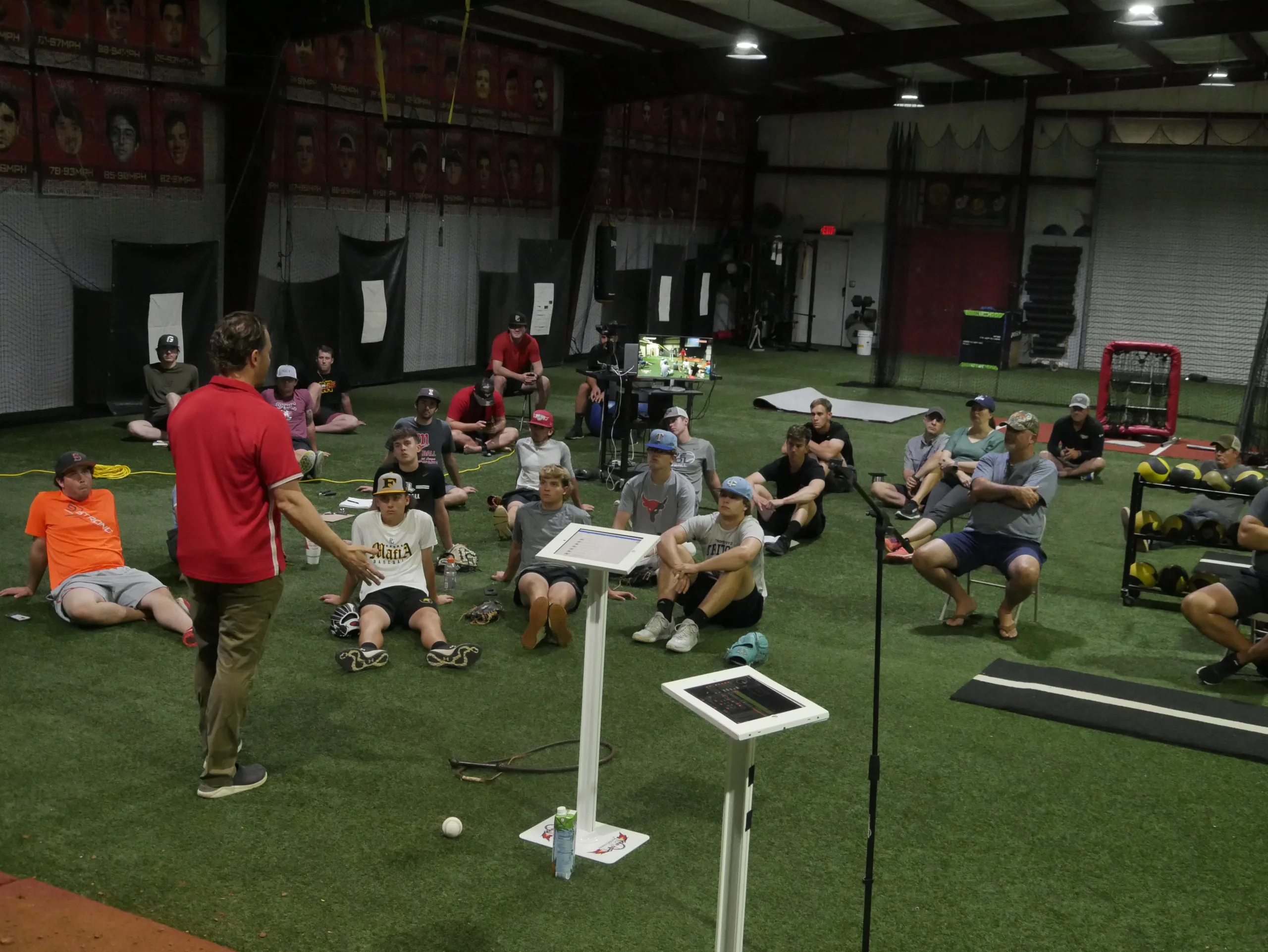 Coach leading group instruction on the turf inside the TopVelocity baseball training facility.
